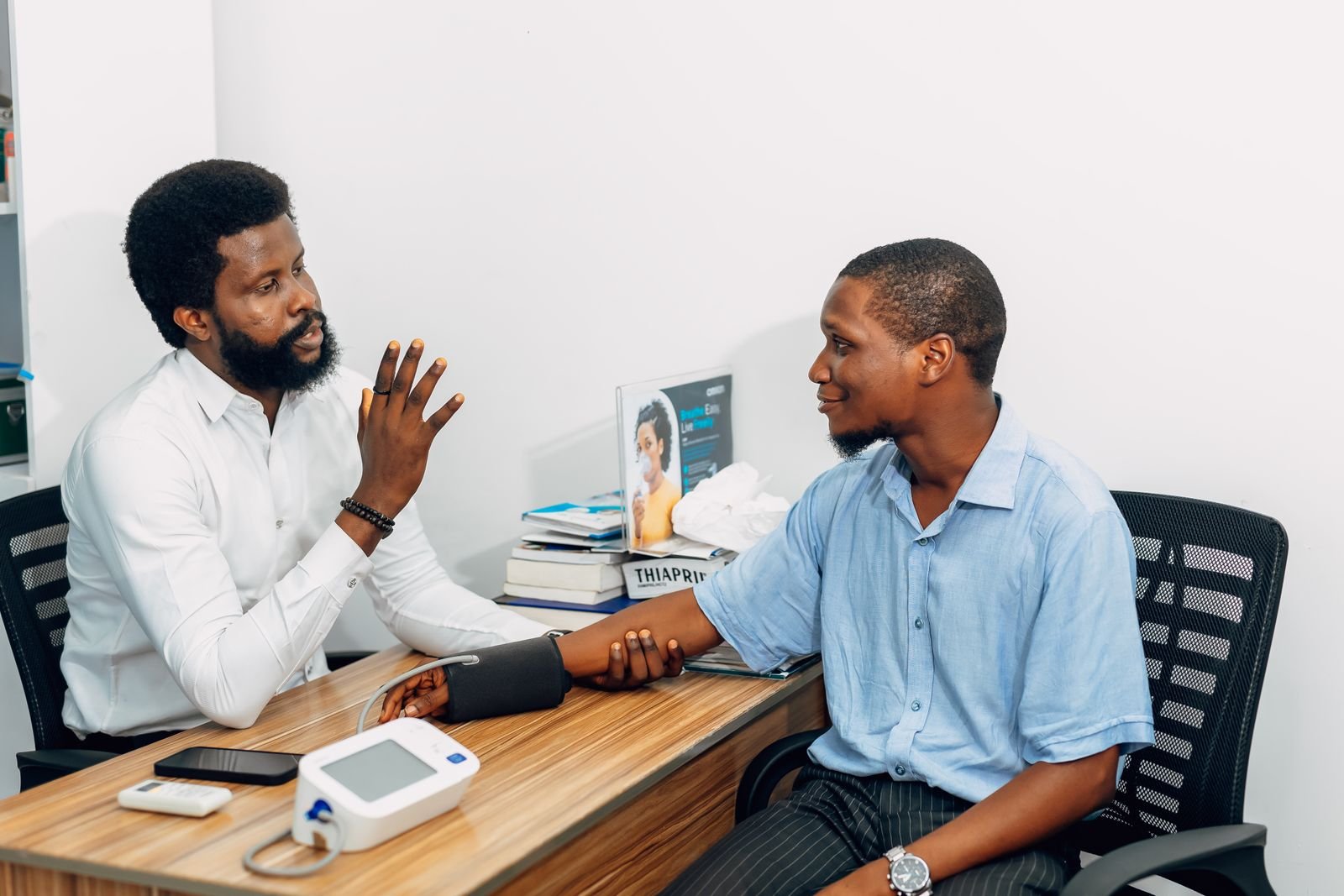 A clinician checks a patient’s blood pressure during a consultation