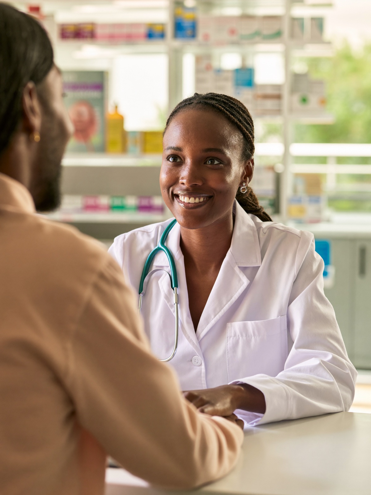 A Kenyan pharmacist advising a customer in store
